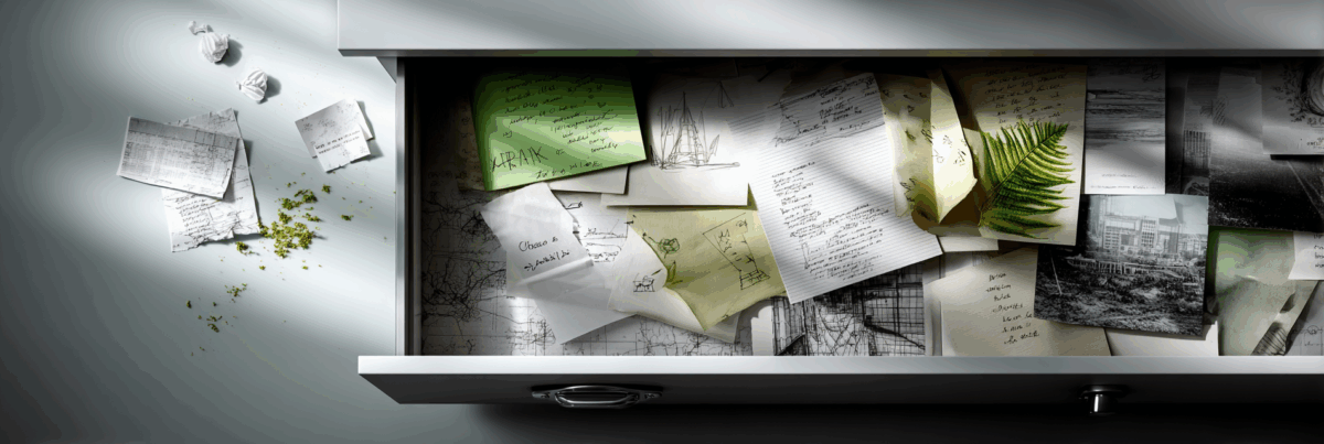 An open drawer filled with scattered handwritten notes, sketches, and photos, evoking a messy yet inspiring creative “everything” drawer.